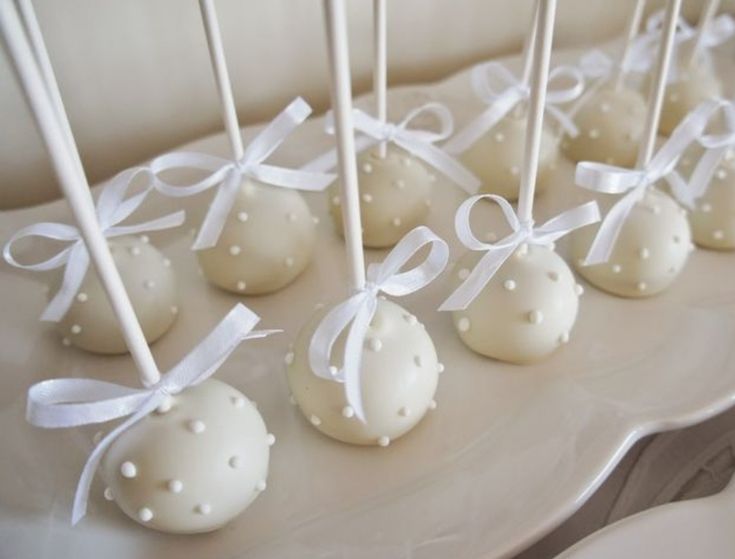 cake pops with white frosting and bows tied around them