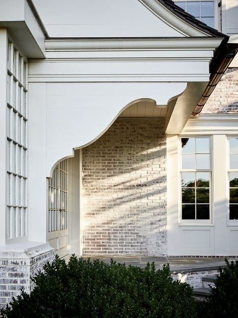 the corner of a white building with an arched window