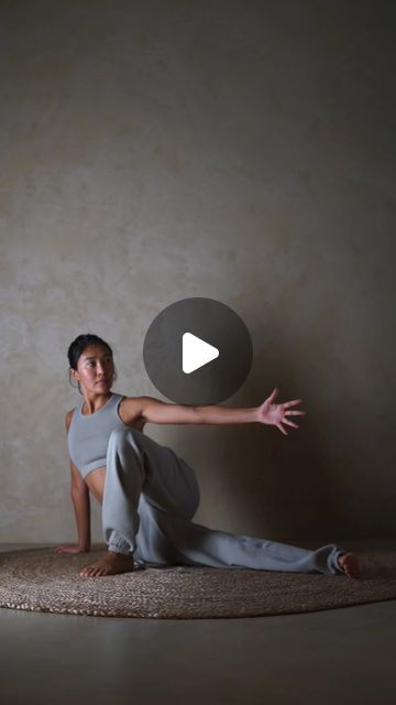 a woman is sitting on the floor with her arms outstretched