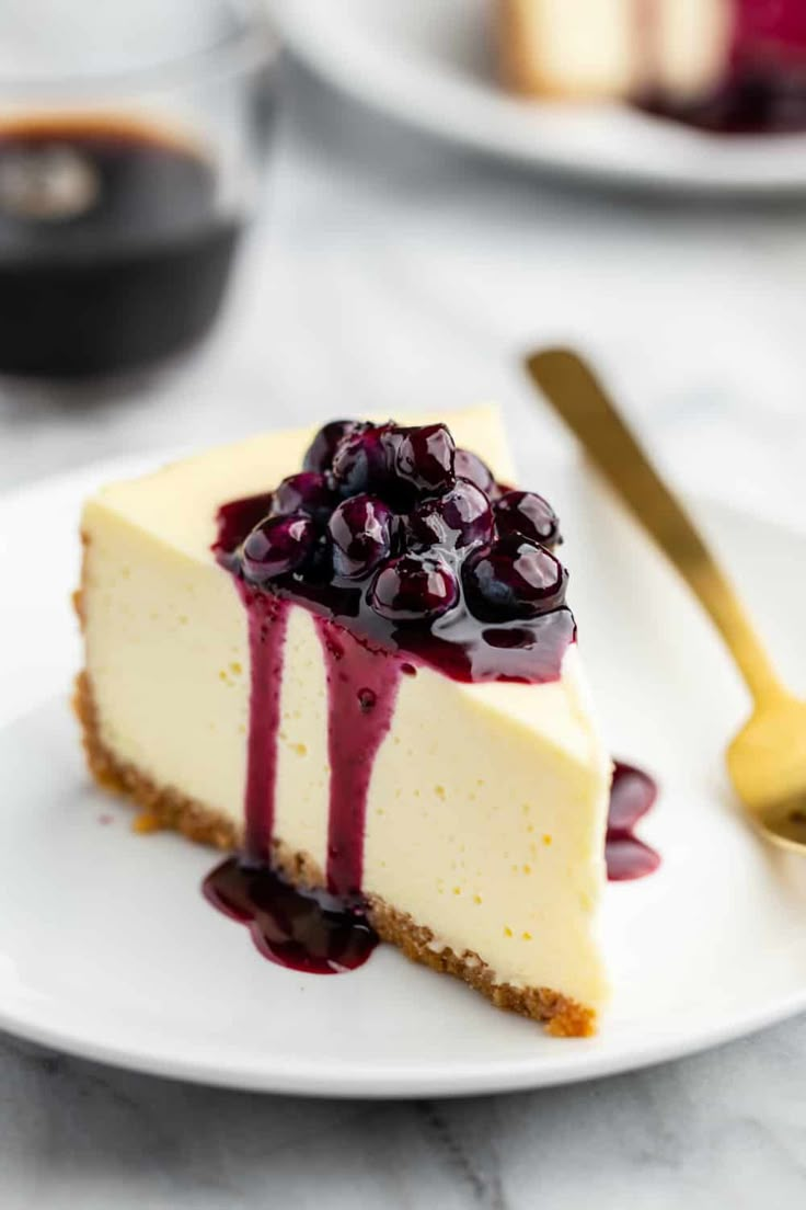 a slice of cheesecake with blueberry sauce on a white plate