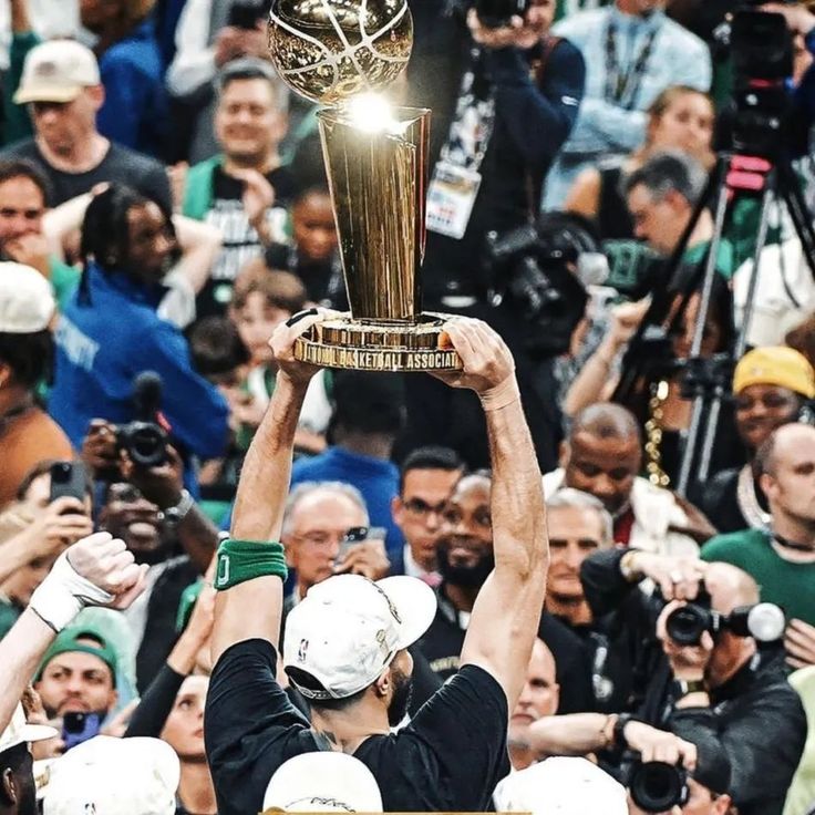 a man holding up a trophy in front of a crowd