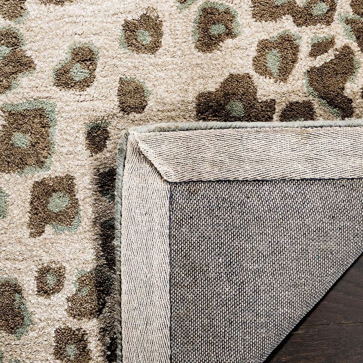 the corner of a rug with an animal print pattern on it and a wooden floor