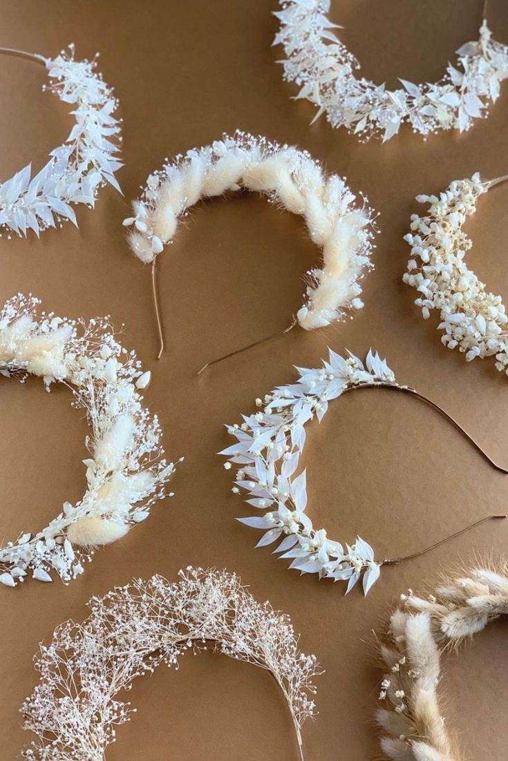 several white wreaths are laid out on a brown surface