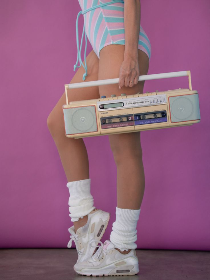 a woman in high heels is holding a boombox with her legs crossed and wearing white socks