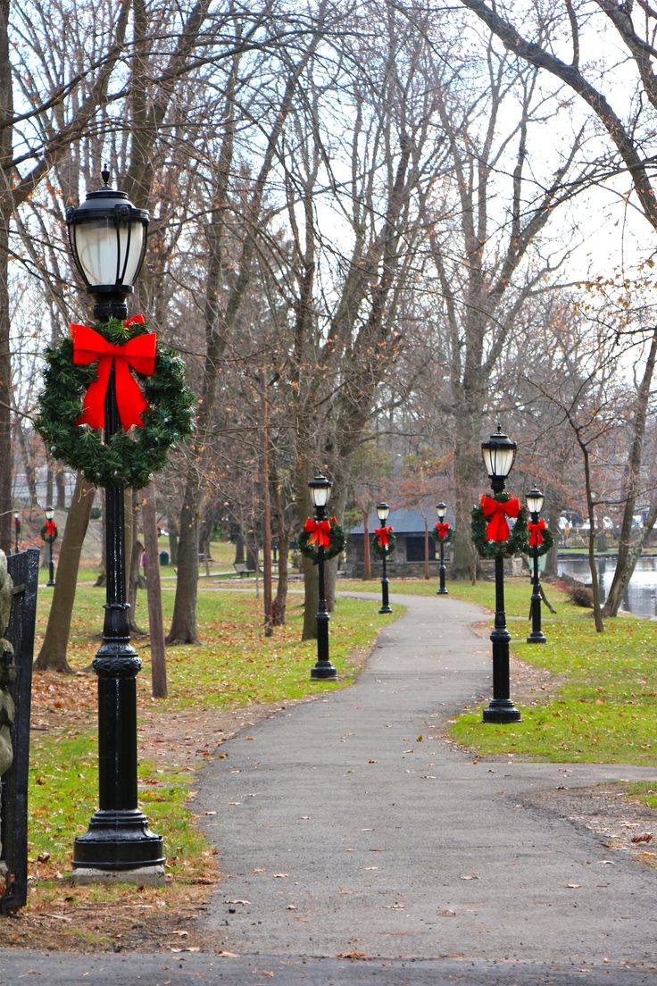 a street light with a wreath on it and lights attached to the poles next to it