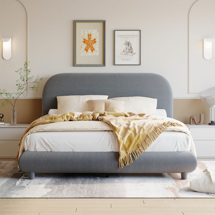 a bedroom with a bed, nightstands and pictures on the wall above it in neutral colors