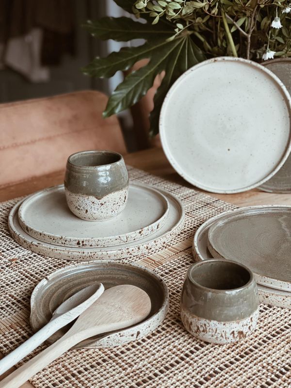 the table is set with dishes, cups and spoons