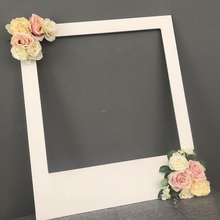 an empty white frame with flowers on the bottom and one flower in the middle, against a gray background