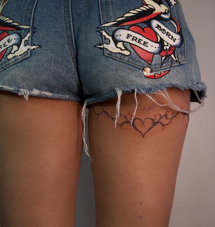 the back of a woman's jean shorts with tattoos on them