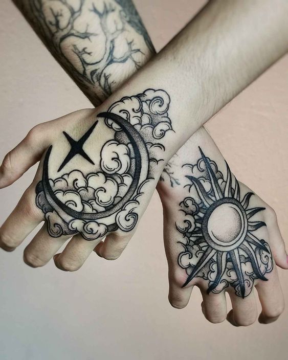 two hands with tattoos on them holding each other's arms and the sun and moon