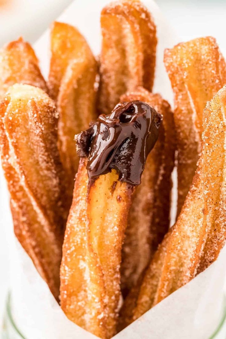 chocolate covered churro sticks in a glass container