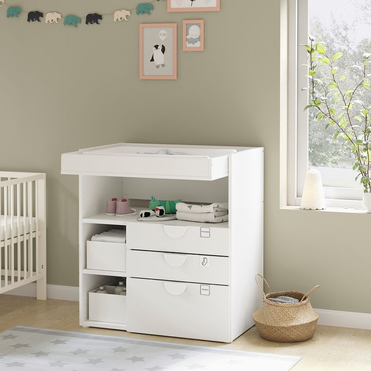 a baby's room with a crib, dresser and changing table in it