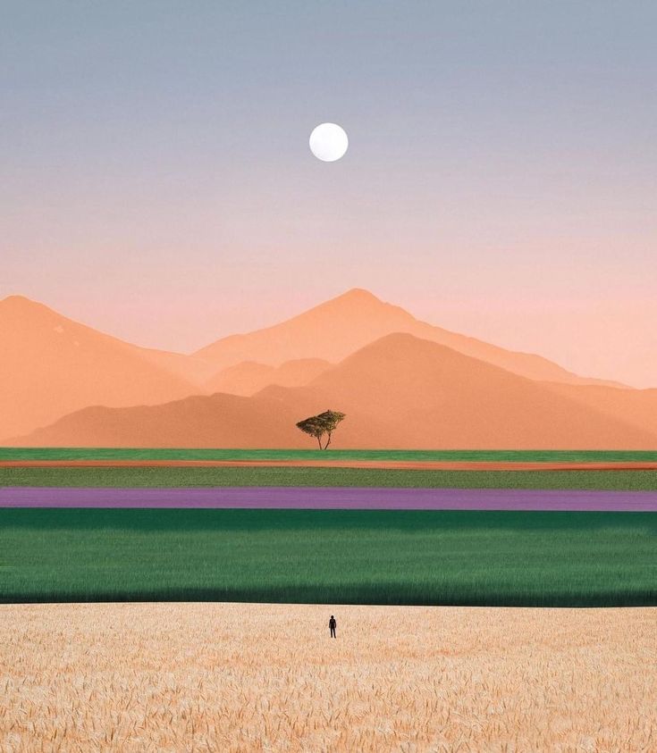 a lone tree stands in the middle of an empty field with mountains in the background