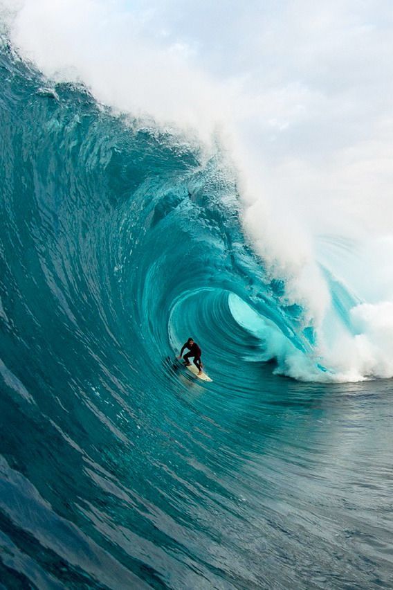 a man riding a wave on top of a surfboard