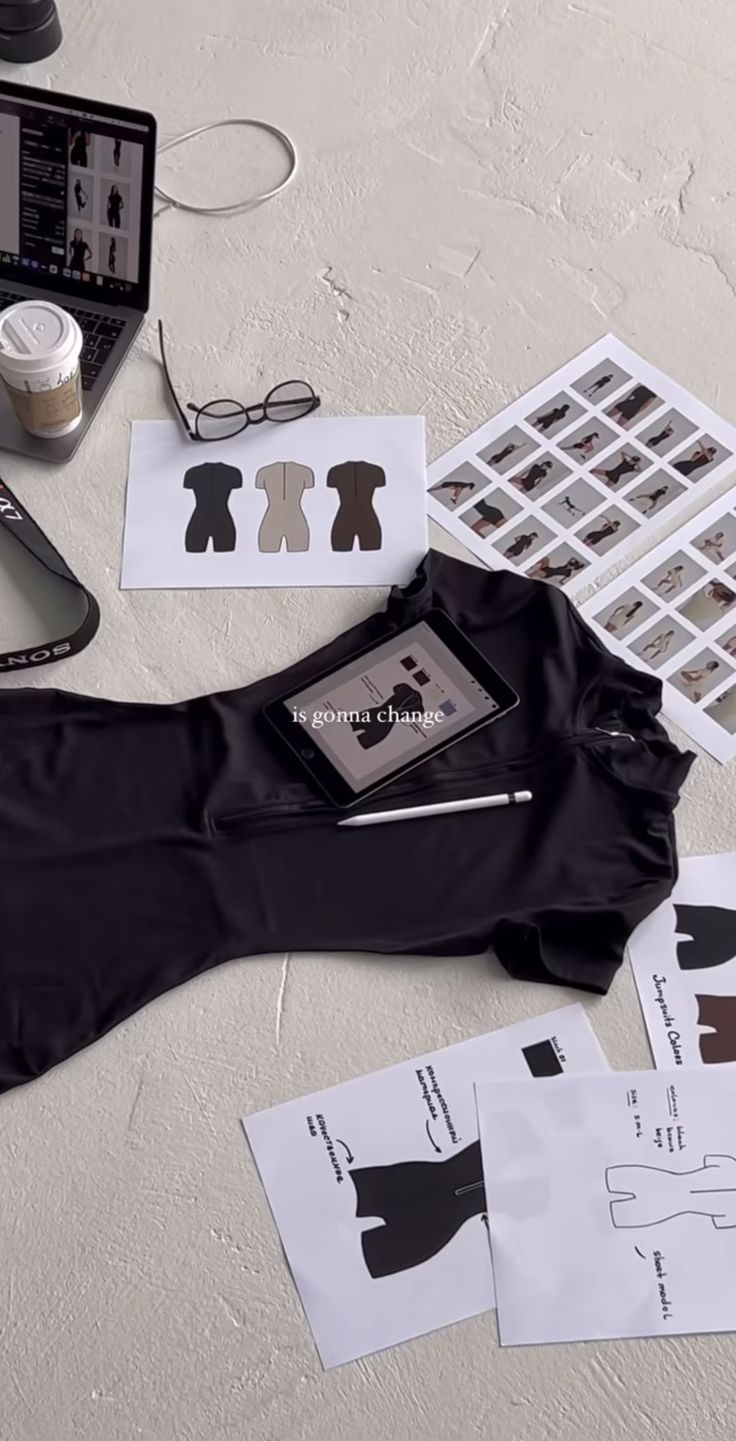 a table topped with paper cut outs and laptop computer sitting on top of each other