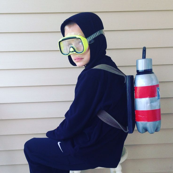 a person sitting on a stool wearing goggles and holding a water bottle