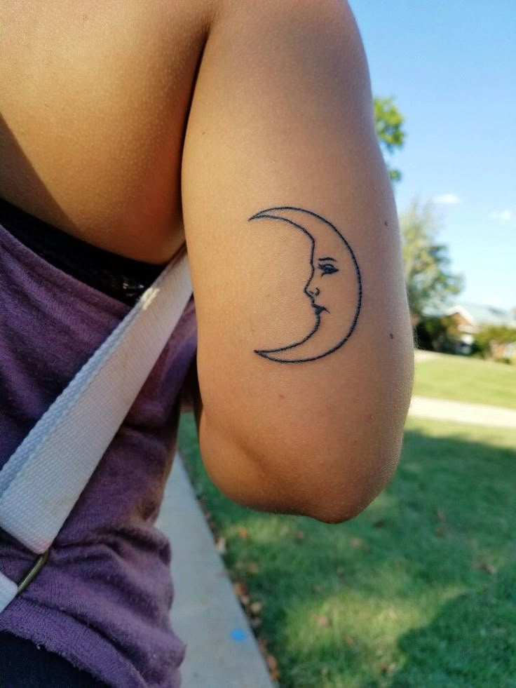 a woman's arm with a tattoo on it that has a crescent moon in the middle