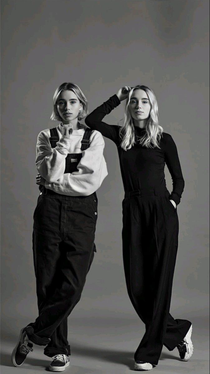 two women standing next to each other in black and white