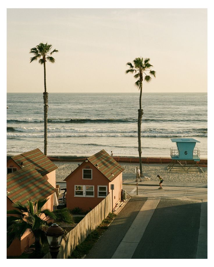 the beach is lined with houses and palm trees