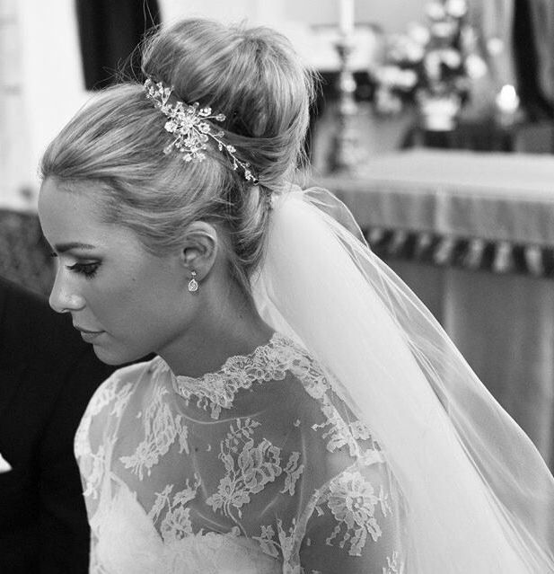 the bride and groom are looking down at their wedding vows in this black and white photo