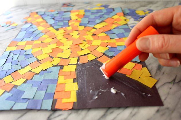 a person is using a paintbrush to decorate a mosaic