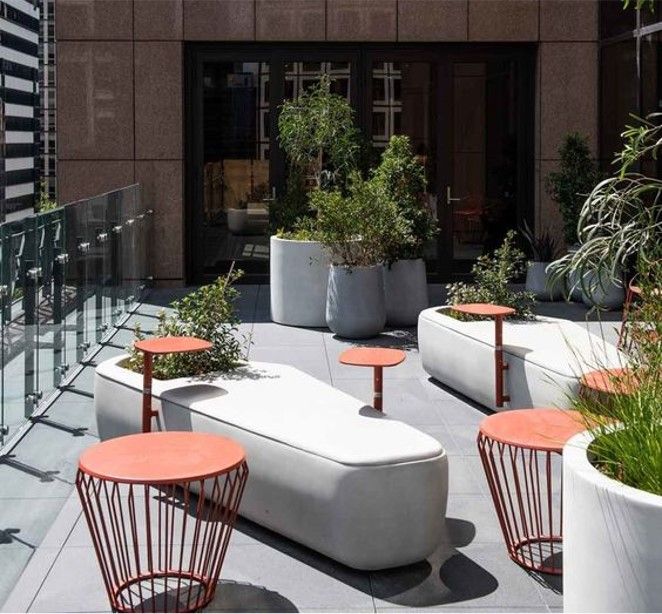 an outdoor seating area with planters and tables