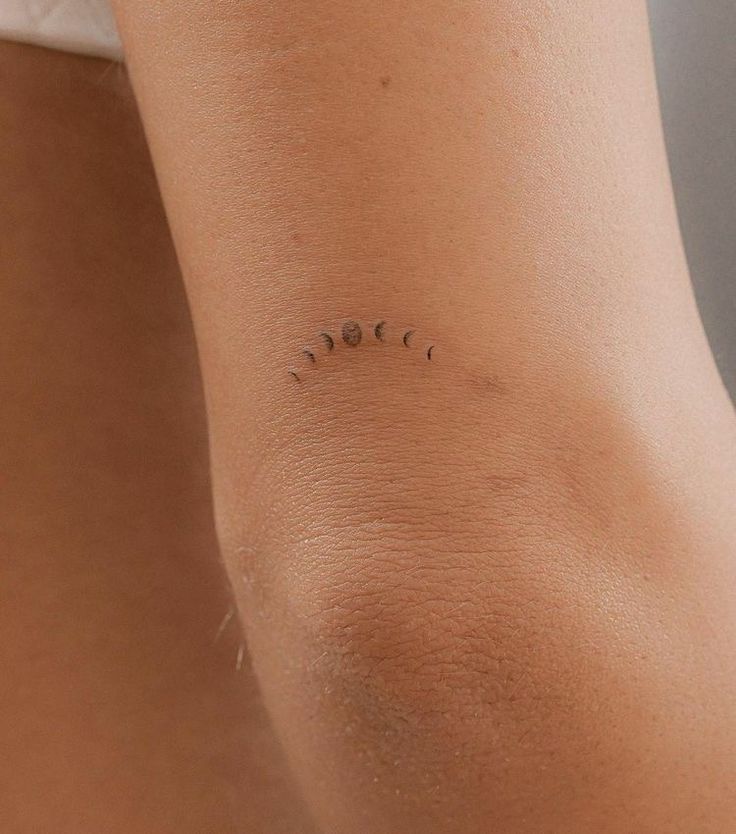 the back of a woman's arm with three small dots on her left side