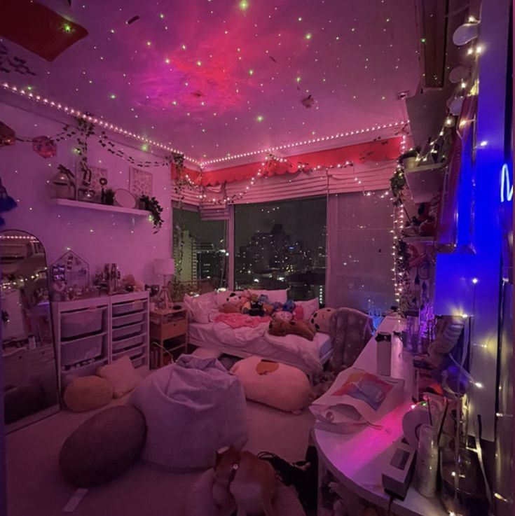 a room filled with lots of clutter and furniture covered in pink lights at night