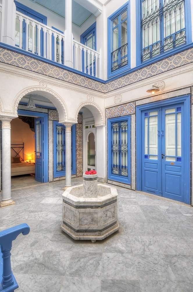 the inside of a building with blue and white doors, windows, and a fountain