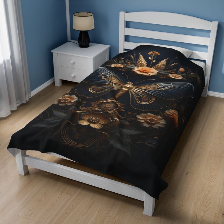 a bed in a room with blue walls and wooden floors, has a black floral print on the comforter