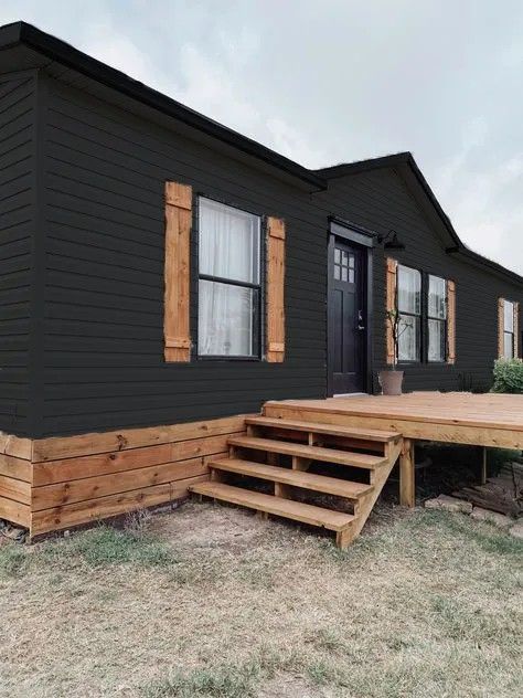 a small black house with steps leading up to it