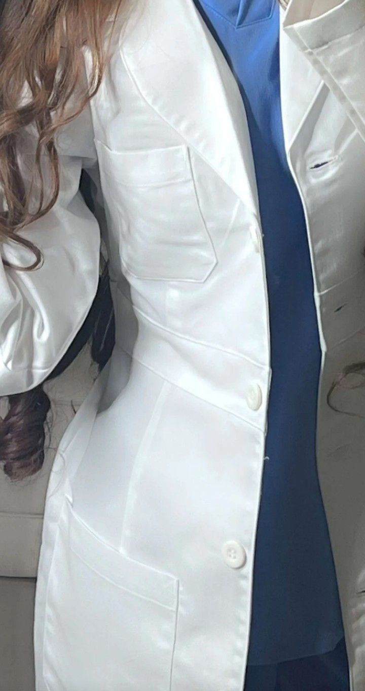 a woman wearing a white suit and blue tie