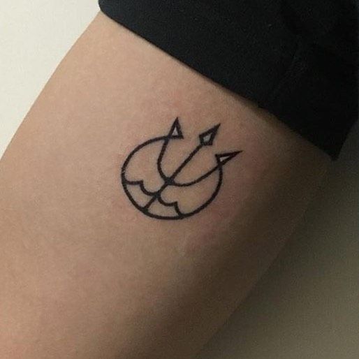 a small tattoo on the leg of a woman's thigh, with an arrow in the middle