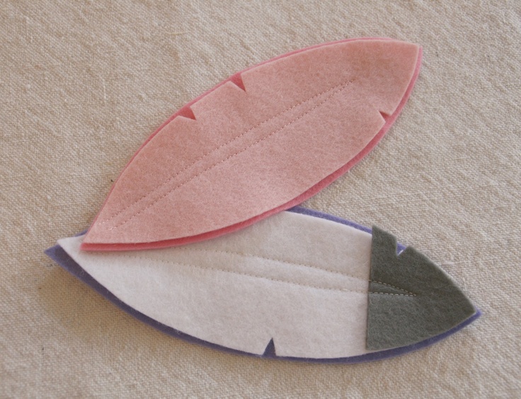 two pieces of felt sitting next to each other on top of a white cloth covered surface