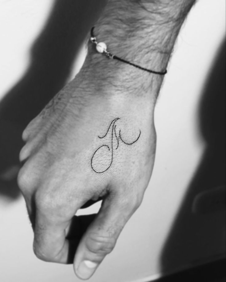 a person's hand with a small tattoo on it