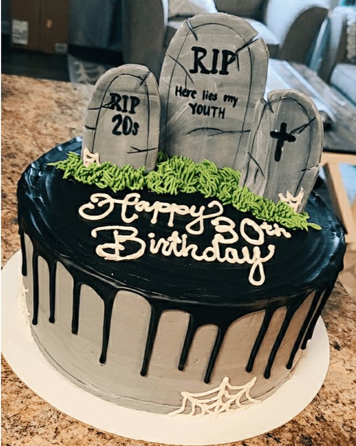 a birthday cake decorated with tombstones and grass