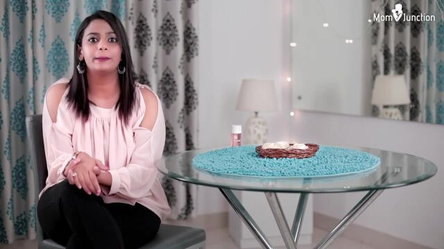 a woman sitting in front of a table with a cake on it