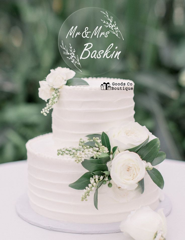 a wedding cake with white flowers and greenery