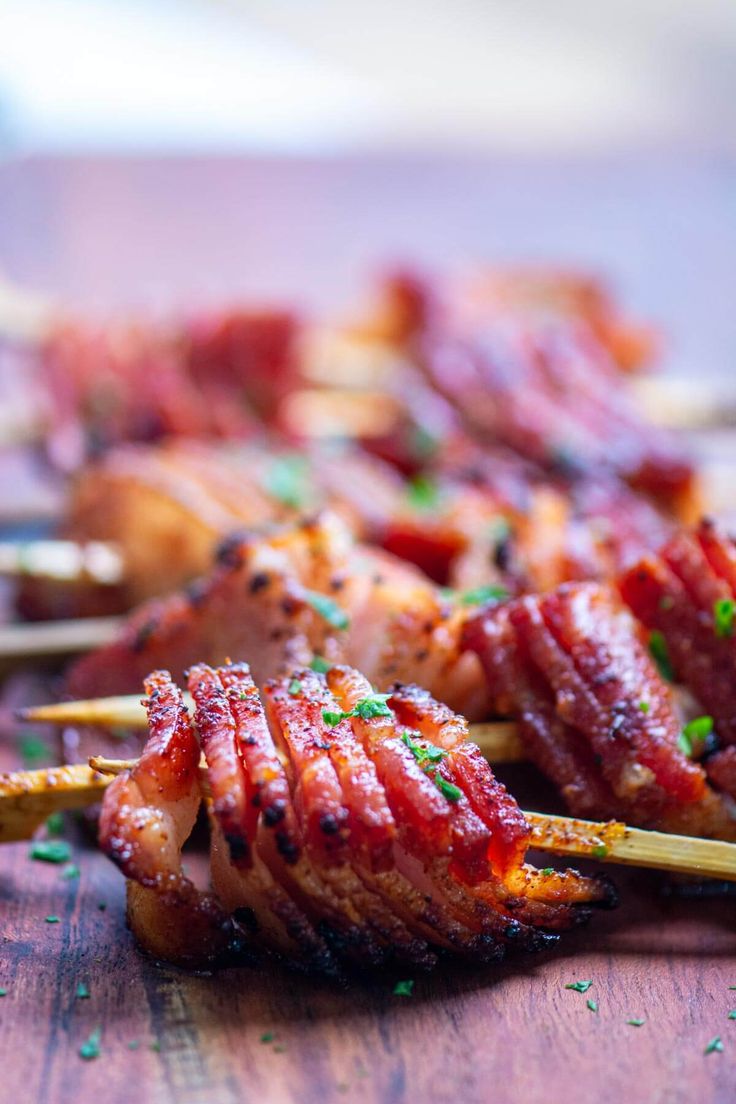 several skewered meats on sticks with parsley sprinkled on them