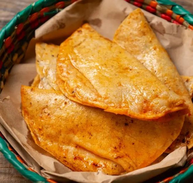 three quesadillas in a basket on a table