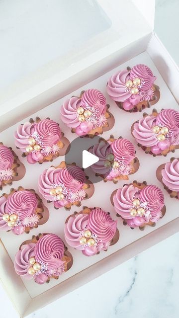 cupcakes with pink frosting in a white box