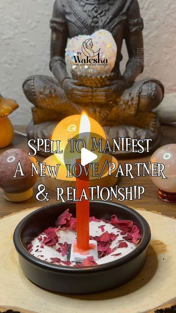 a candle sitting on top of a wooden table next to a buddha figurine