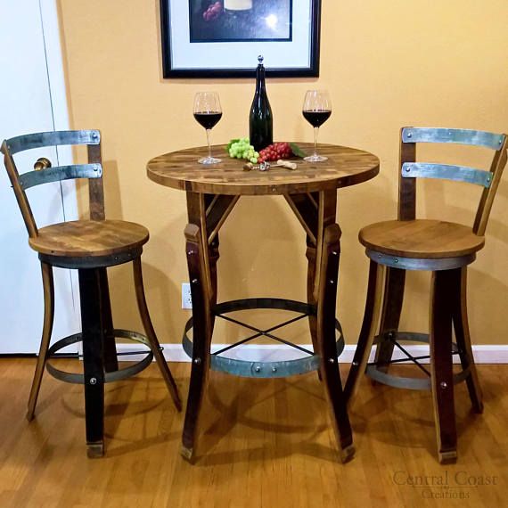 two chairs and a table with wine glasses on it in front of a framed photo