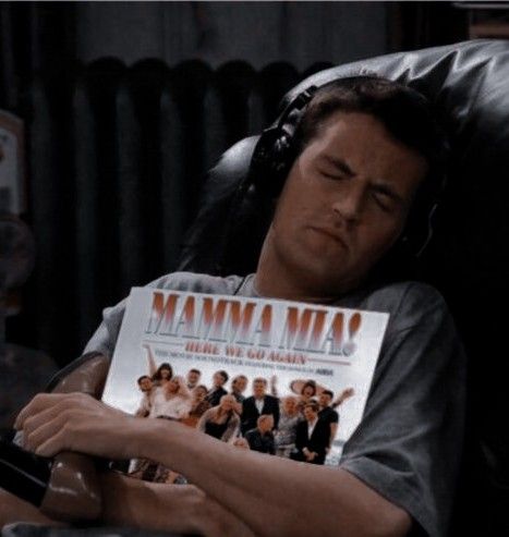 a man sleeping on a couch holding a magazine with the movie mamma mia written on it