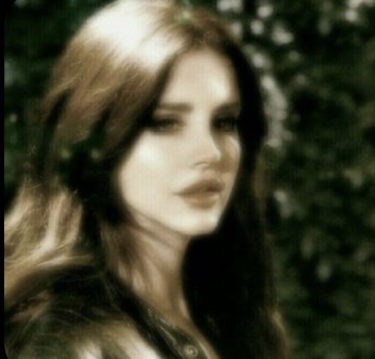 a blurry photo of a woman with long hair and trees in the back ground