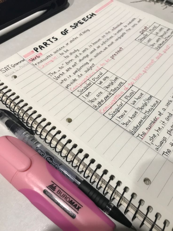 a pink pen sitting on top of an open notebook