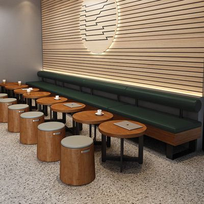 a row of benches sitting next to each other in front of a wall with wooden slats