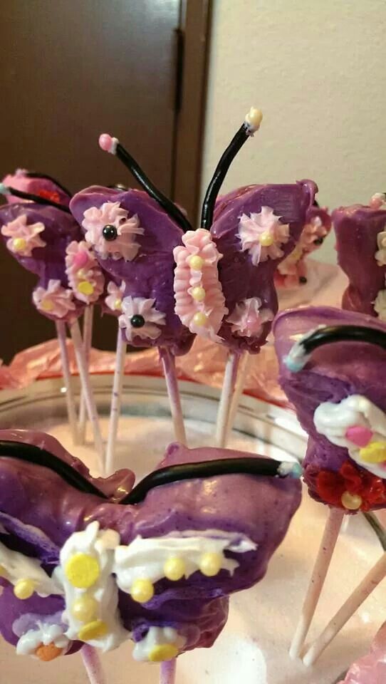 purple cake pops decorated with flowers and candy