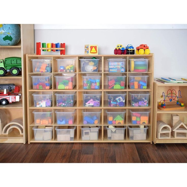 a room filled with lots of toy bins and toys on top of wooden shelves