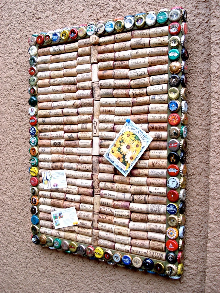 a cork bulletin board made out of wine bottles on the side of a building with magnets attached to it